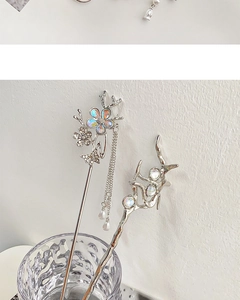 Detail of silver tassel hair pins with floral butterfly motifs and moonstone accents