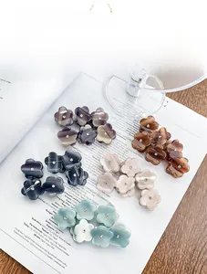 Détail macro de mini pinces à cheveux fleur en acétate avec strass sur magazine