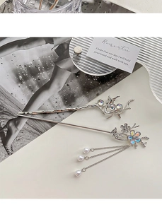Detail of silver moonstone hair sticks with plum blossom charms and pearl tassels