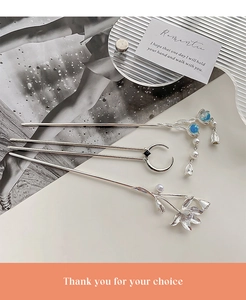 Detailed macro view of moonstone tassels and intricate flower patterns on metal hair sticks