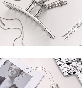Detail der silbernen Metallhaarklammer mit Kettengliedern auf einem Wellentablett