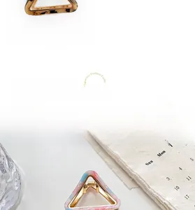 Details von Dreieck-Haarklammern in Beige-Schildpatt und Marmor-Optik mit Goldrahmen