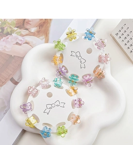 Macro view of mini flower hair clips with glitter finish in assorted macaron colors