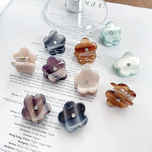 Mini pinces à cheveux fleurs en acétate avec strass couleurs assorties sur un magazine