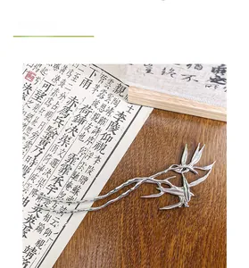 Detail of silver bamboo leaf hair stick with elegant branch and bird motif