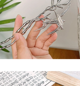 Close-up of silver bamboo leaf hair fork with intricate detail in a hand-held view