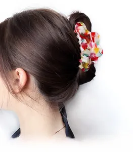 Dettaglio del fermaglio per capelli a nuvola in acetato a fiori colorati sul modello