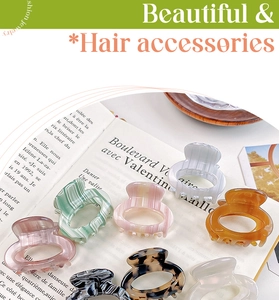 Variety of colorful acetate hair claws displayed elegantly on an open French book