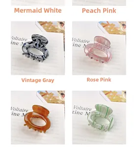 Detail view of acetate hair claws in various marble colors on a stylish display