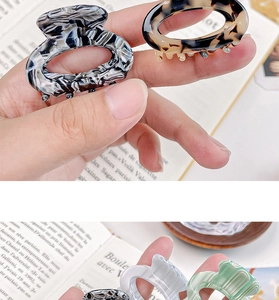Close-up of tortoise shell and marble acetate hair clips for high ponytail styling