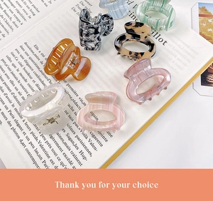 Detailed close-up of acetate hair claws in various patterns on a vintage book