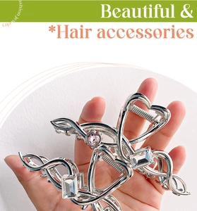 Close-up of silver hair claw clip with pink heart crystal and sparkling rhinestones