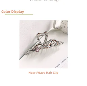 Detail view of large wave hair claw with pink heart crystal and silver metal finish