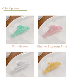 Detail showing dolphin hair clips in glittery mint green, cherry pink, and yellow colors