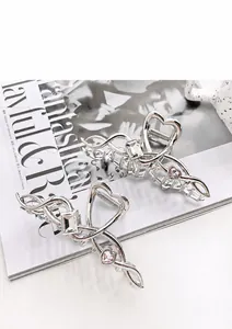 Detail of silver shark hair clip with pink heart crystal and rhinestones on magazine
