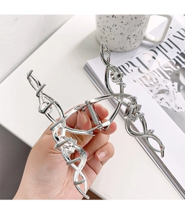Detailed view of a large silver geometric metal hair claw clip featuring elegant rhinestones