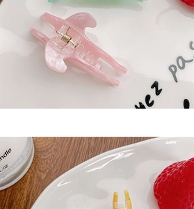 Detail view of colorful dolphin hair clips with marble texture and metal spring mechanism
