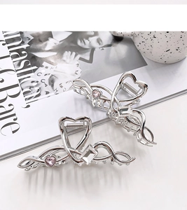 Detail of silver wavy metal hair claw with pink heart crystal and sparkling zircon accents