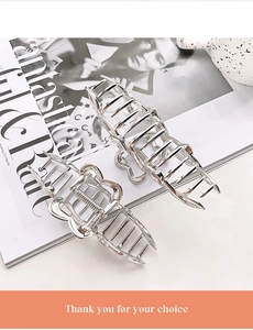 Detailed view of silver metal hair claw set with zircon accents on a marble background