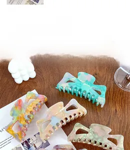 Gros plan de pinces à cheveux en acétate marbré de différentes couleurs sur bois