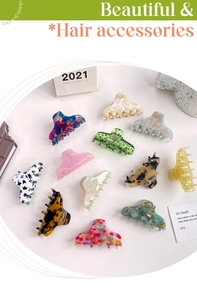 Flat lay of multiple acetate hair claws in marble and floral patterns on white background