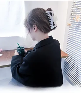 Détail d'une grande pince à cheveux en acétate nacré pour coiffer les cheveux épais