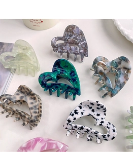 Flat lay of diverse heart-shaped acetate hair claws in leopard and marble patterns