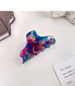 Detail of artistic acetate hair claw clip with colorful marbling and gold foil flakes
