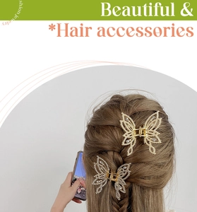Detail showing two gold butterfly hair claws with rhinestones on braided hair