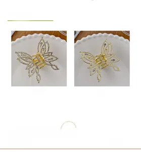 Detail of gold butterfly hair claws with shiny rhinestones and elegant white pearls