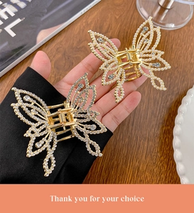 Close-up of golden butterfly hair claw clip with faux pearls and sparkling rhinestones