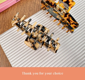 Detail of tortoise shell acetate hair claws showing high-quality texture and metal spring