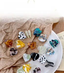 Detailed close-up of acetate heart hair claws in various marble and tortoiseshell patterns
