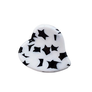 Minimalist heart-shaped acetate hair claw clip with black and white polka dot pattern