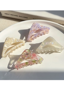 Detailed view of four geometric acetate hair claws in assorted marble and floral patterns