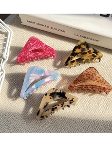 Detailed macro view of five geometric acetate hair claws in various marbled patterns