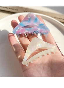 Detail view of two geometric triangle hair claws with marble texture and pearl luster finish