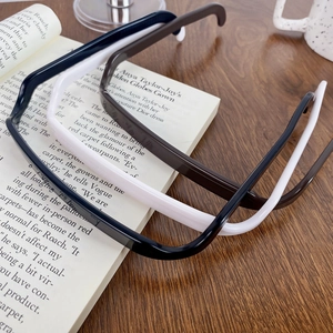 Modern square-shaped hairbands in black and cream resin finish on a wooden desk
