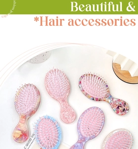 Détail de mini brosses à cheveux en acétate avec motifs marbrés et poils en nylon