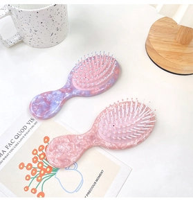Détail de brosses à cheveux massantes avec motif marbré sur une surface blanche