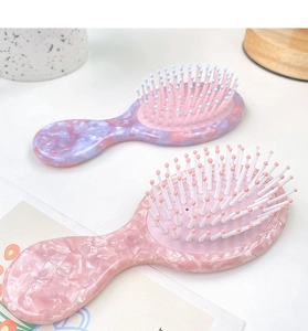 Détail de brosses à cheveux en acétate marbré avec coussin massant et poils colorés