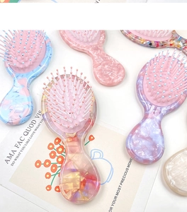 Détail de mini brosses à cheveux avec manches en acétate marbré et pailleté