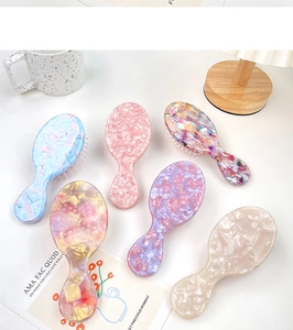 Vue détaillée de six brosses à cheveux à coussin d'air en acétate coloré marbré