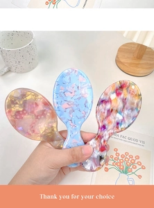 Détail des brosses à cheveux en acétate avec texture coquillage et coussin d'air massant