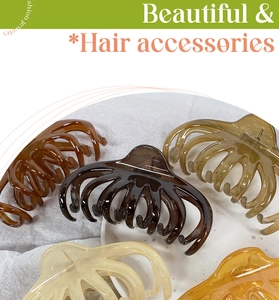 Detail of five large resin octopus hair claw clips in elegant translucent earthy tones