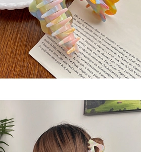 Detail view of large candy-colored marble texture hair claw clip on wooden background