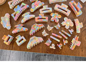 Flat lay of diverse candy-colored acetate hair claws with marble texture on wooden background