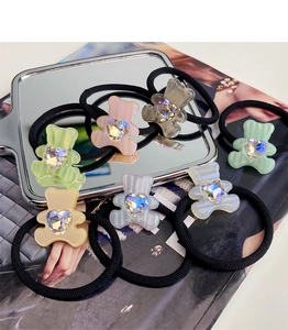 Close-up of candy-colored acetate bear hair ties with aurora crystal heart detail