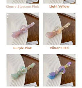 Dettaglio di fermagli a fiocco in acetato nei colori rosa ciliegia, giallo, viola e rosso
