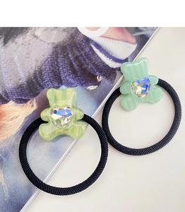 Detail of candy color bear hair ties with heart-shaped crystal on clear acetate bears